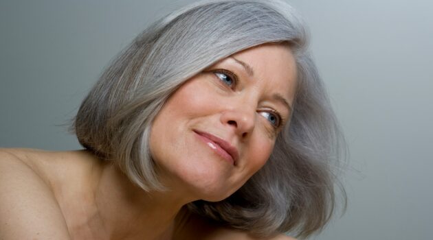 Close-up of a woman with a smooth grey bob hairstyle and natural makeup
