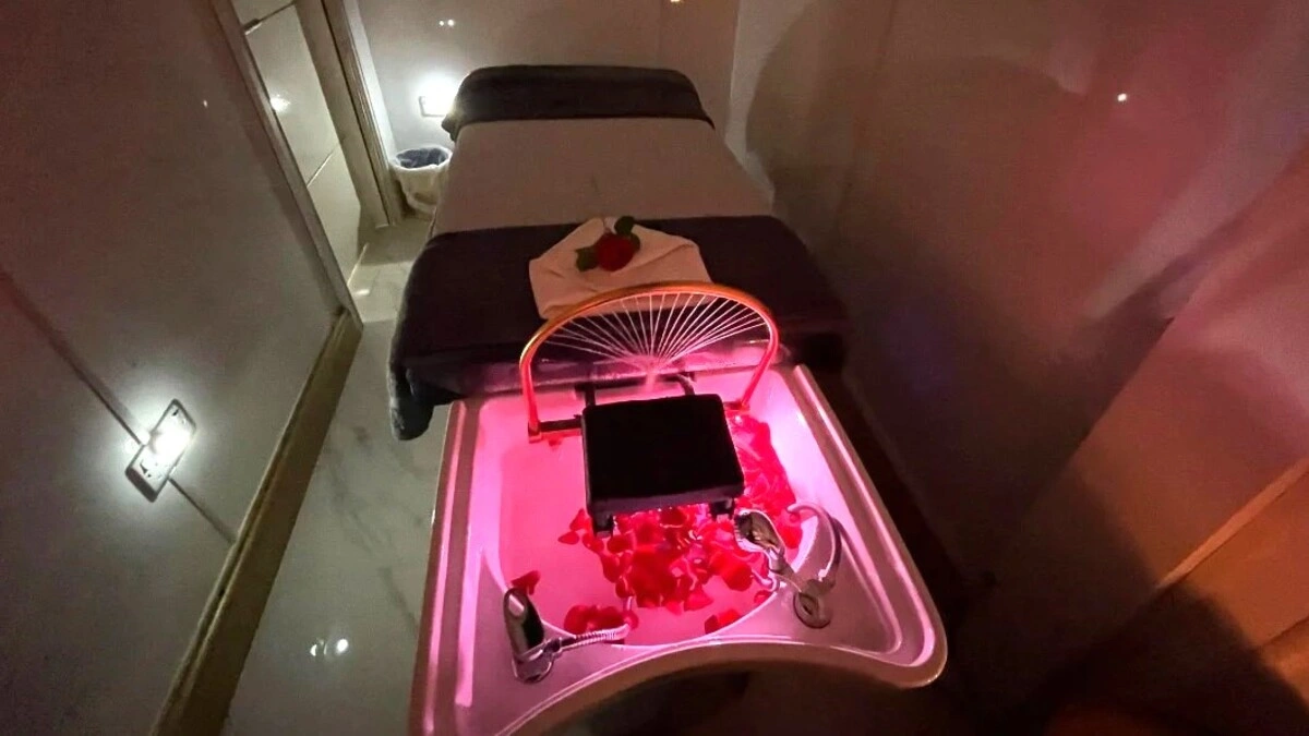 Inside a relaxing Japanese head spa treatment room with dimmed lights showing a treatment bed, basin with petals and spa equipment