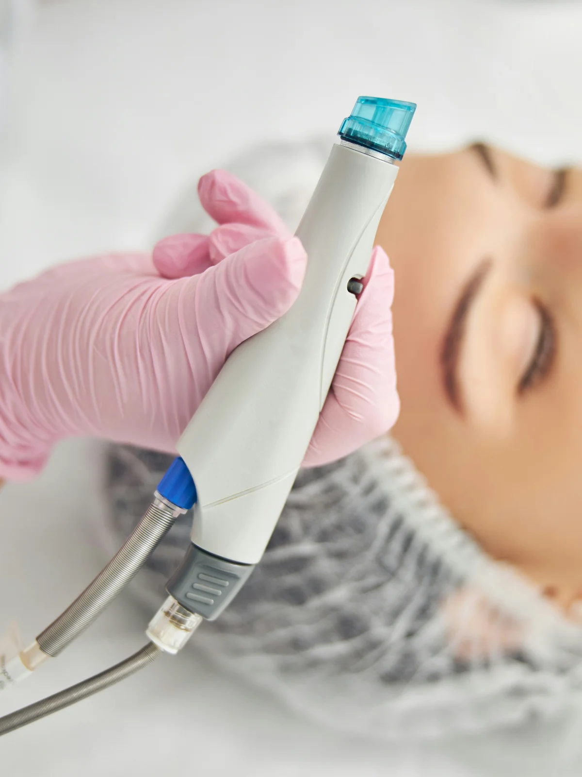 Close-up of a HydraFacial device with a spiral tip held by a practitioner