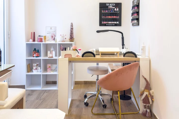 Manicure station at Gd Beauty Clinc di Giulia Delogu in Alghero with a pink velvet chair and Top Notch nail-polish display.